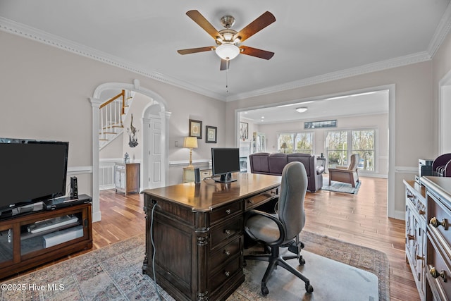 home office with crown molding, ceiling fan, and light wood-type flooring