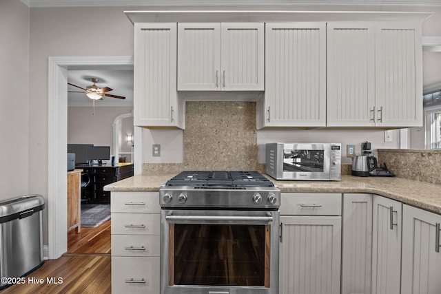 kitchen with white cabinetry, appliances with stainless steel finishes, wood-type flooring, and backsplash