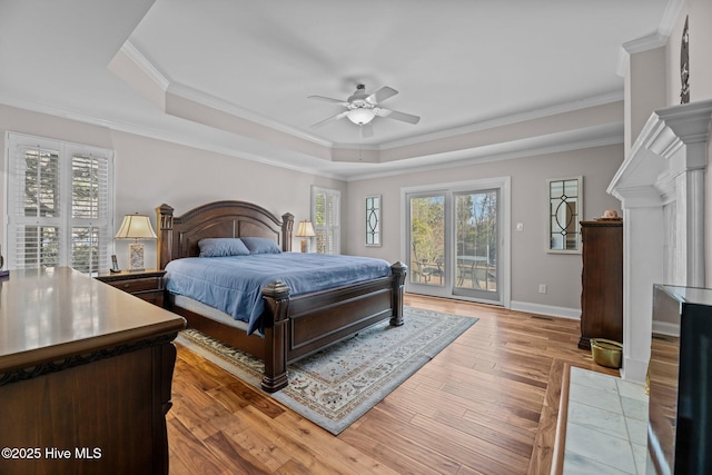 bedroom featuring ceiling fan, a tray ceiling, and multiple windows