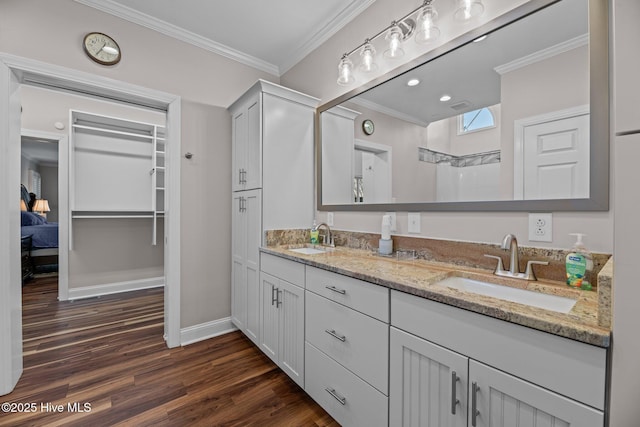 bathroom featuring vanity, hardwood / wood-style floors, ornamental molding, and a shower