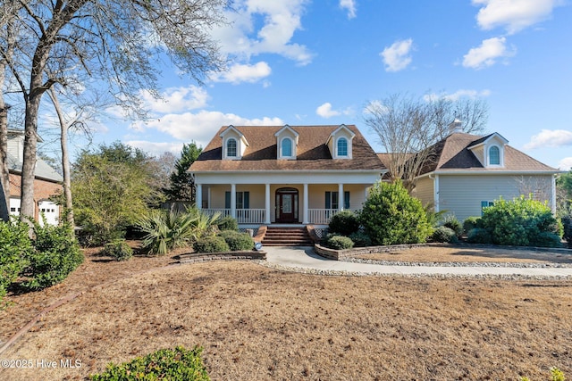 cape cod home featuring covered porch