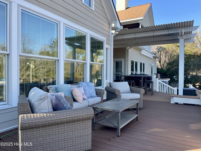 wooden deck with an outdoor living space and a pergola