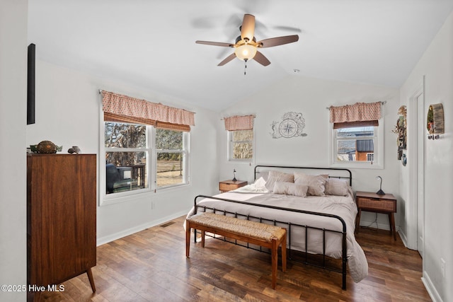 bedroom featuring ceiling fan, multiple windows, lofted ceiling, and hardwood / wood-style floors