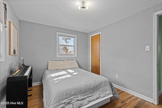 bedroom with dark hardwood / wood-style floors