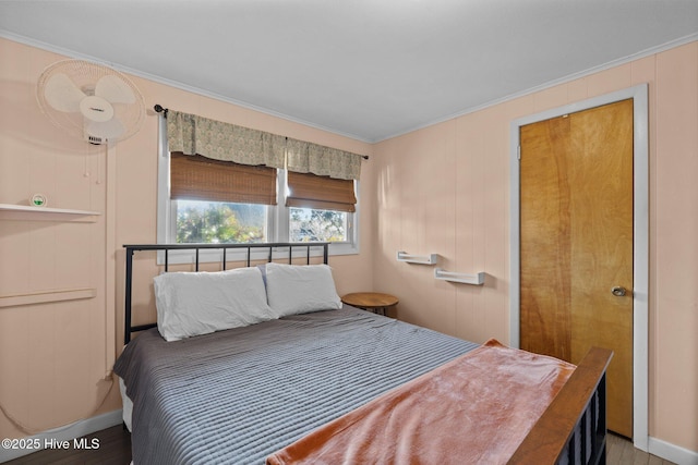 bedroom with hardwood / wood-style flooring and ornamental molding