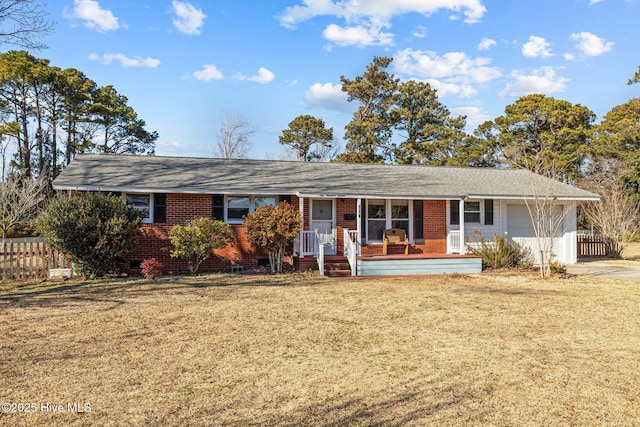 single story home with a front yard, covered porch, and a garage