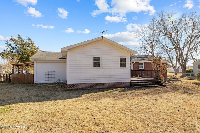 back of property with a deck and a yard