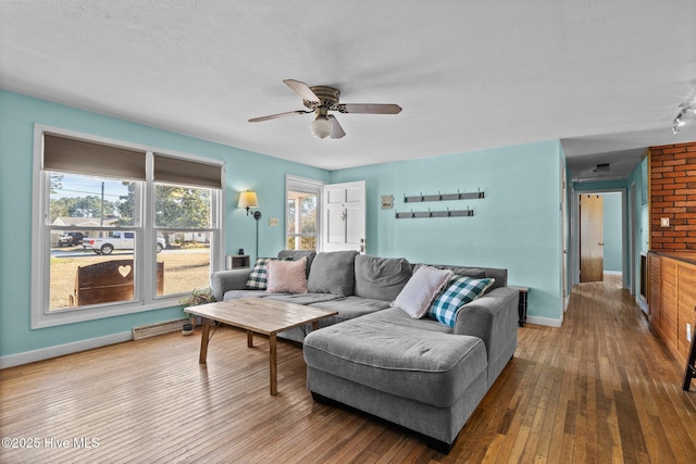 living room featuring ceiling fan, wood-type flooring, and a textured ceiling