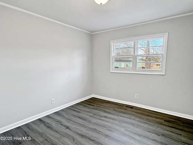 empty room featuring dark hardwood / wood-style flooring and ornamental molding