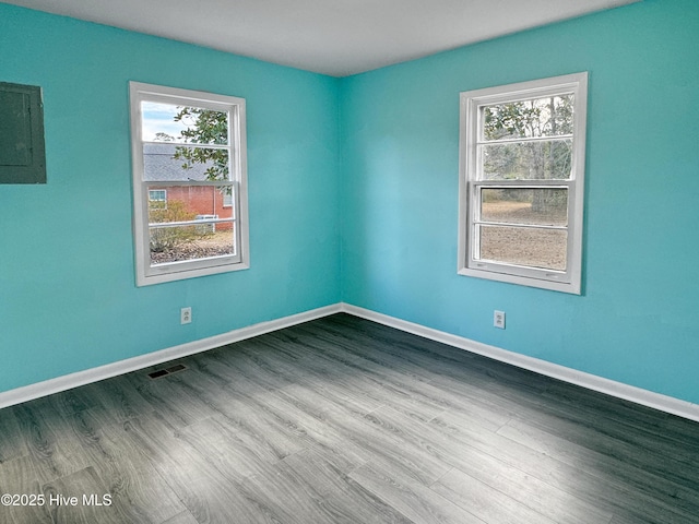 spare room featuring electric panel and hardwood / wood-style floors