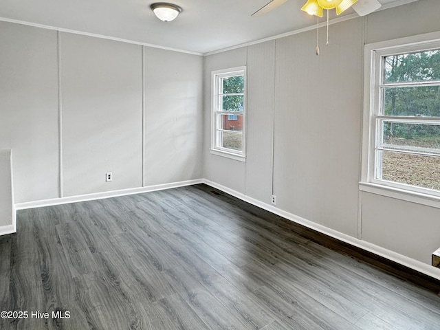 unfurnished room featuring dark hardwood / wood-style flooring, ornamental molding, and plenty of natural light