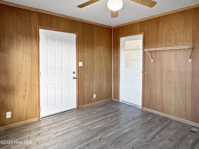 entrance foyer featuring wooden walls, hardwood / wood-style flooring, and crown molding