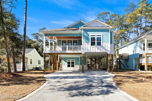 coastal home with cooling unit, a carport, and covered porch