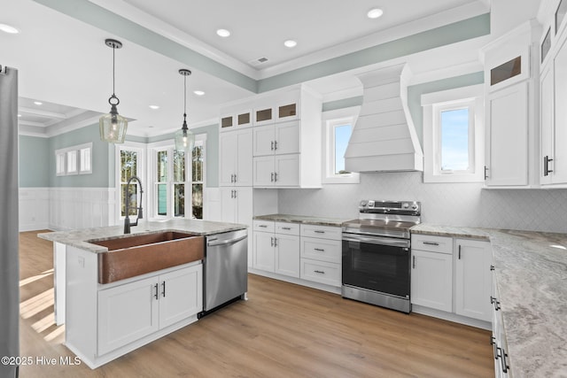 kitchen with appliances with stainless steel finishes, custom exhaust hood, white cabinets, and sink