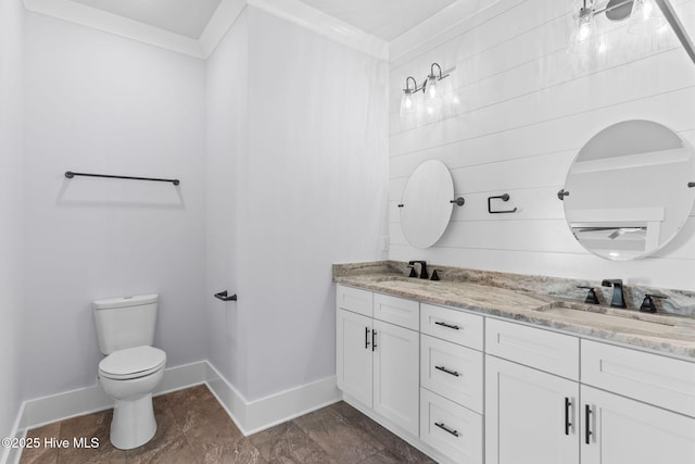 bathroom featuring toilet, vanity, and crown molding