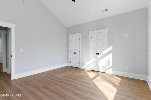 unfurnished room featuring high vaulted ceiling and light wood-type flooring