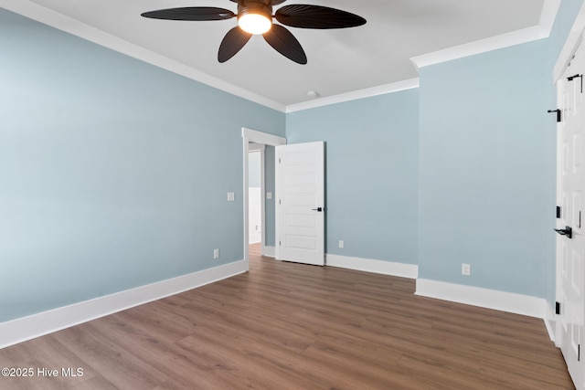 empty room featuring hardwood / wood-style floors, ornamental molding, and ceiling fan