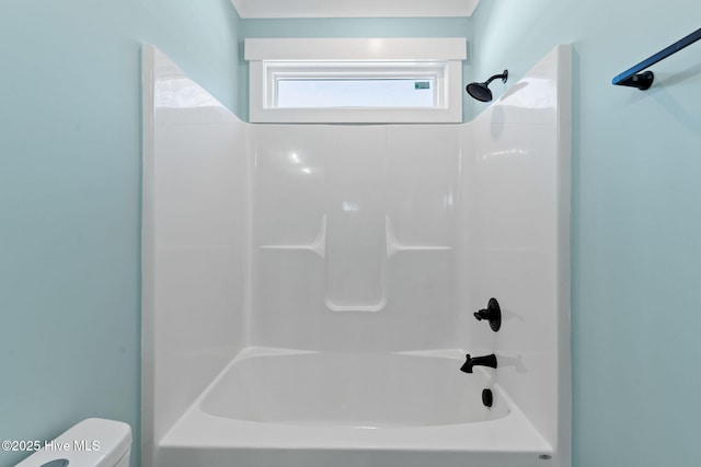 bathroom featuring tub / shower combination and toilet