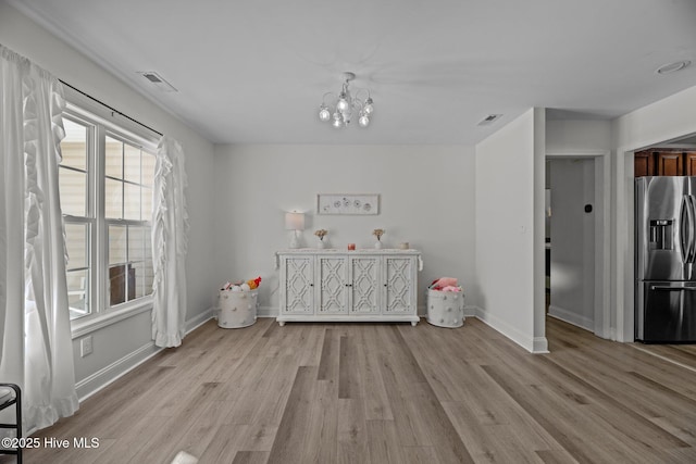 interior space with light hardwood / wood-style floors and a notable chandelier