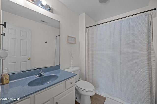 bathroom with hardwood / wood-style flooring, vanity, and toilet