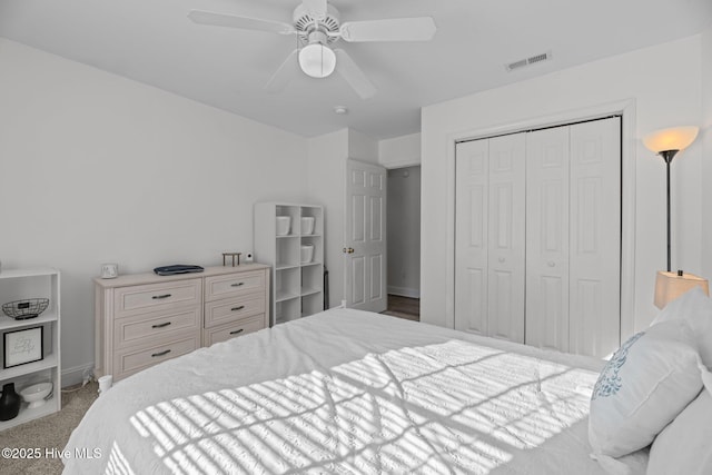 carpeted bedroom with ceiling fan and a closet