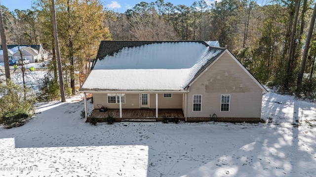 snow covered house featuring a deck