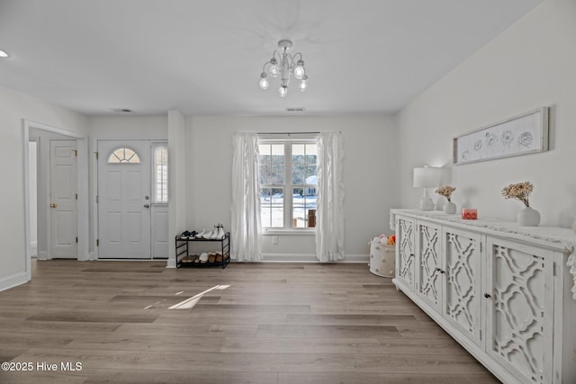 foyer with a notable chandelier and light hardwood / wood-style flooring