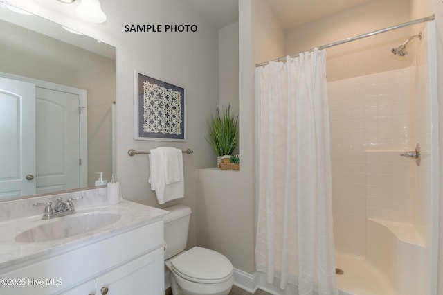 bathroom with a shower with curtain, vanity, and toilet