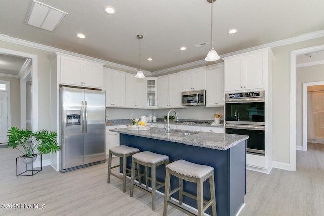 kitchen featuring hanging light fixtures, sink, white cabinets, and stainless steel appliances