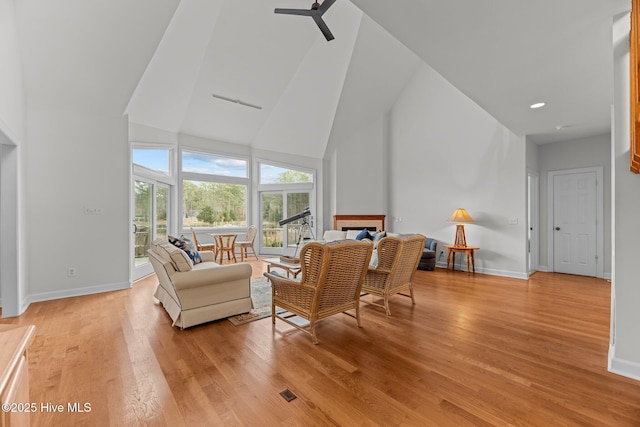 living room featuring high vaulted ceiling, ceiling fan, and light hardwood / wood-style flooring