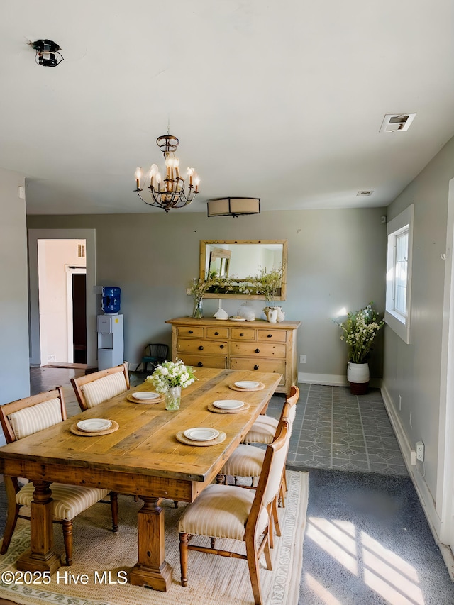 tiled dining space with a chandelier