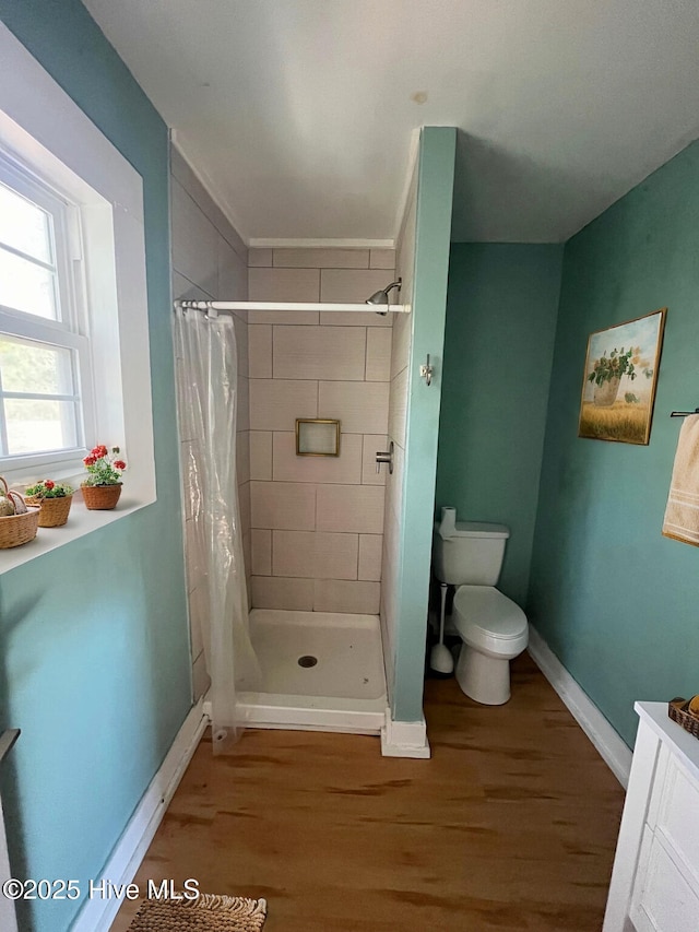 bathroom featuring curtained shower, toilet, vanity, and hardwood / wood-style flooring