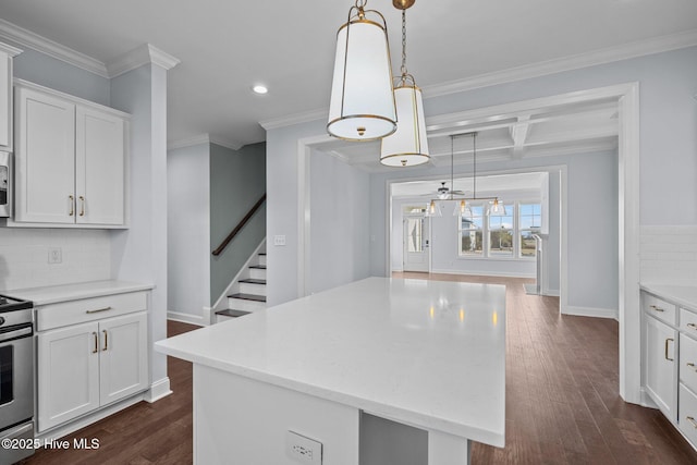 kitchen with white cabinets, decorative light fixtures, a kitchen island, and coffered ceiling