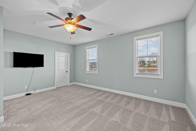 carpeted empty room featuring plenty of natural light and ceiling fan