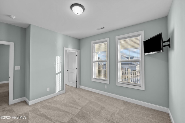 unfurnished room featuring light carpet