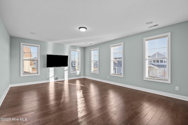 unfurnished living room featuring hardwood / wood-style flooring and a healthy amount of sunlight