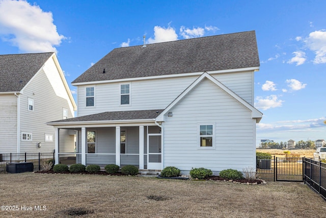 rear view of house with a lawn and a porch