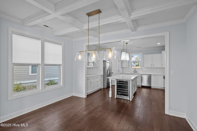 kitchen featuring a center island, tasteful backsplash, pendant lighting, white cabinets, and appliances with stainless steel finishes