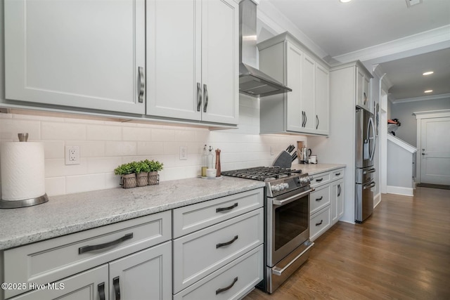 kitchen with crown molding, appliances with stainless steel finishes, tasteful backsplash, light stone countertops, and wall chimney exhaust hood