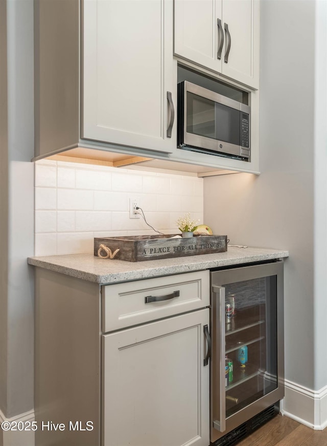 kitchen featuring wine cooler, backsplash, and dark hardwood / wood-style flooring