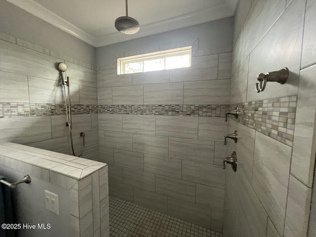 bathroom featuring crown molding and tiled shower