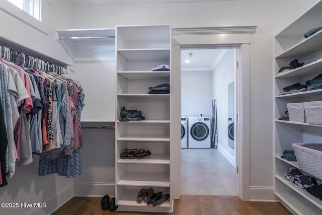 spacious closet with hardwood / wood-style floors and independent washer and dryer