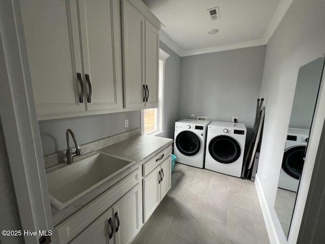 laundry area with sink, cabinets, light tile patterned floors, crown molding, and washer and clothes dryer