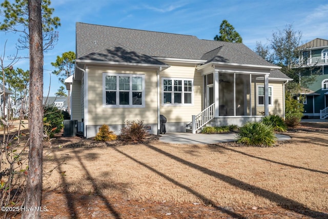 back of property with central AC unit and a sunroom