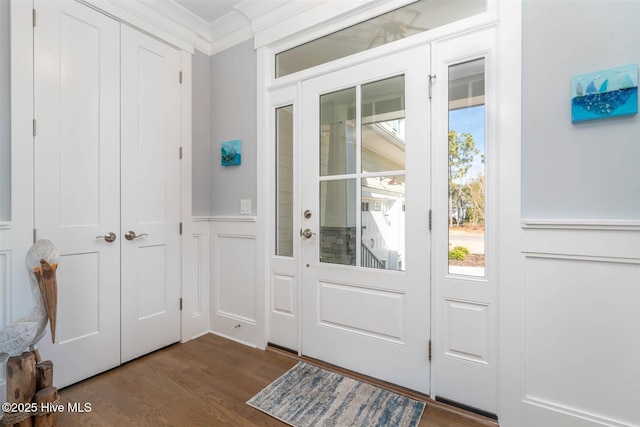 doorway to outside with ornamental molding, plenty of natural light, and dark wood-type flooring