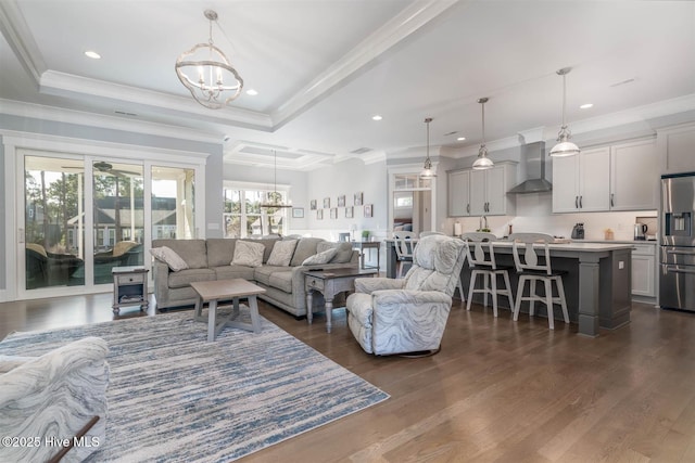 living room with ornamental molding, dark hardwood / wood-style floors, and an inviting chandelier