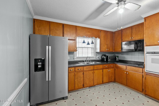 interior space with ceiling fan, a textured ceiling, and crown molding