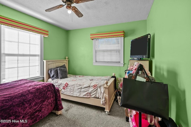 carpeted bedroom with ceiling fan, a textured ceiling, and multiple windows