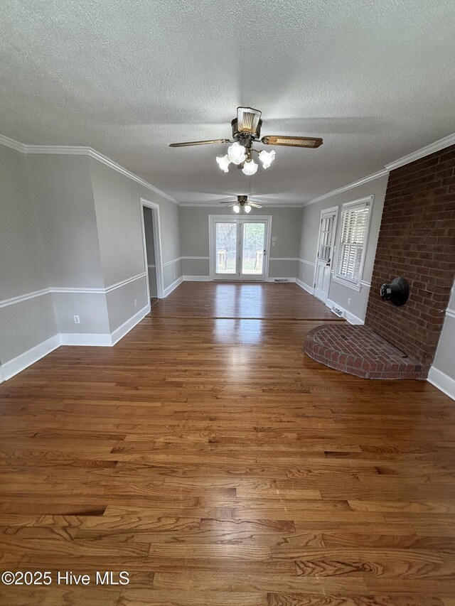 living room with carpet, ceiling fan, ornamental molding, and a textured ceiling