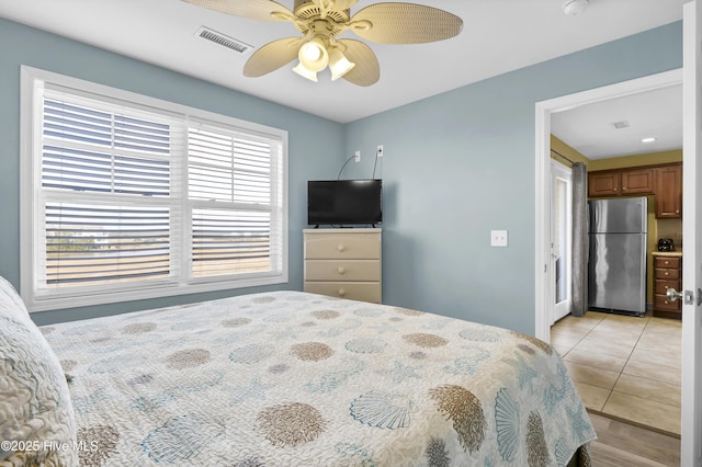 tiled bedroom with stainless steel fridge and ceiling fan